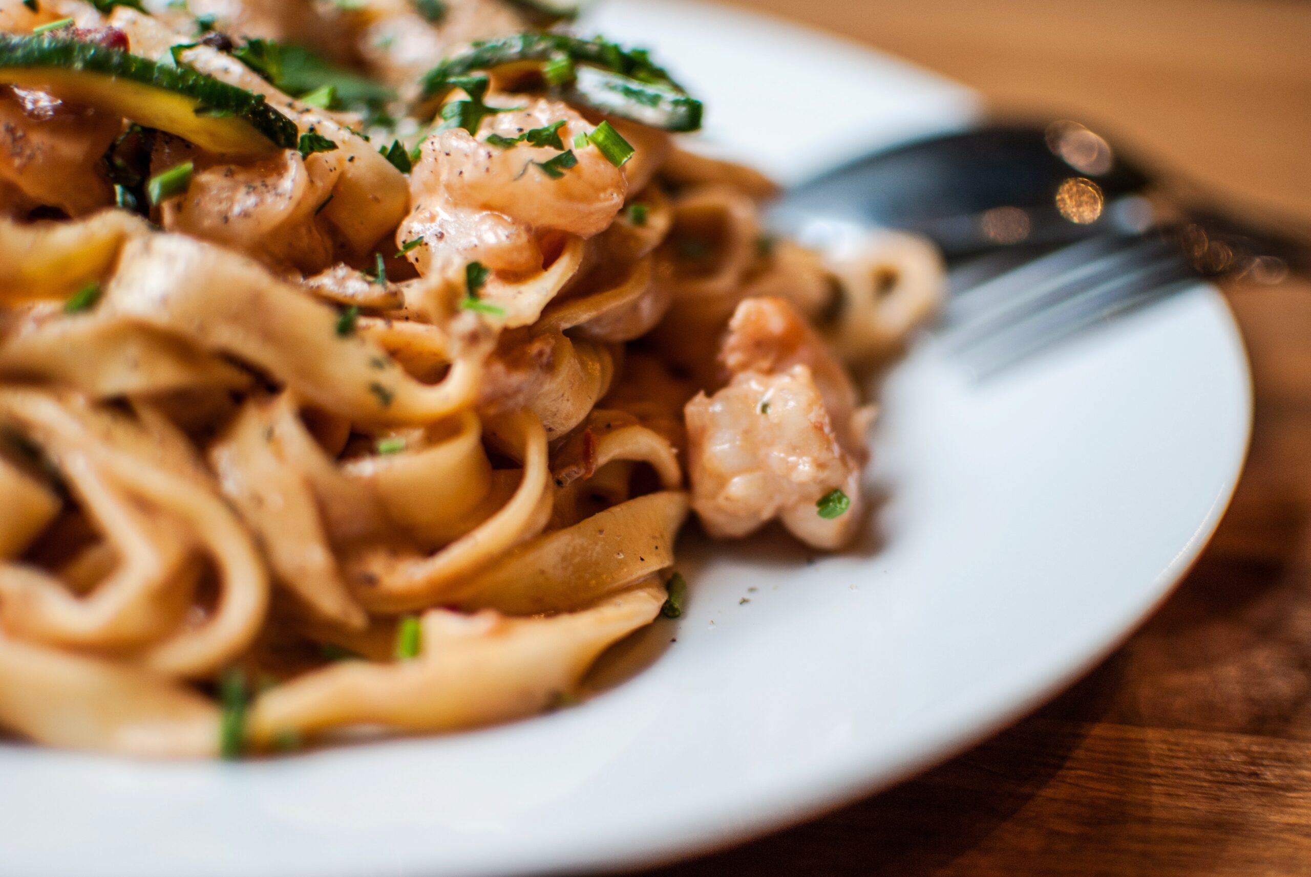 A closeup shot of delicious pasta with shrimps on blurred background